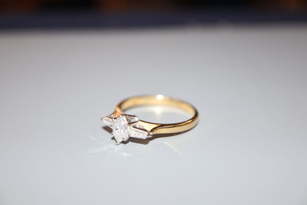 A modern 18ct gold, marquise and trapeze cut diamond set three stone dress ring, size Q, gross 3.1 grams,